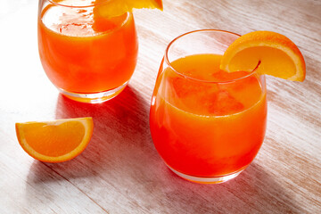 Orange drinks on a wooden background, fresh pressed juice with fruit slices on a rustic table - 761334112