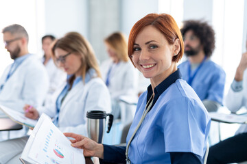 Group of doctors on conference, medical team sitting and listening speaker. Medical experts attending an education event, seminar in board room.