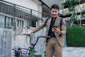 Fototapeta na wymiar asian young businessman use smart phone while commuting in city. Eco friendly