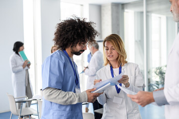 Colleagues doctors taking in hospital corridor. Colleagues, doctors team discussing patients diagnosis. - 761336174