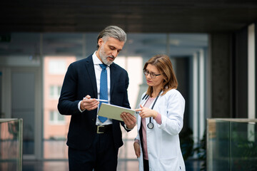 Doctor talking to pharmaceutical sales representative, presenting new medication. Hospital manager...