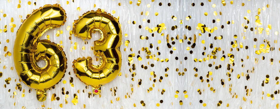 Golden foil balloon number, figure sixty-three on white with confetti background. 63th birthday card. Anniversary concept. birthday, new year celebration. banner,