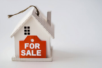 House model with For Sale label on white background. Real estate concept.
