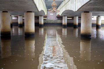 Photo of the underside of a bridge in the city.  - Powered by Adobe
