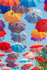 Multicolored umbrellas hanging above street in Antalya in sunny day and blue sky. Book cover. Turkey (Turkiye)