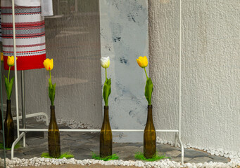 artificial tulips in bottles in a shop window