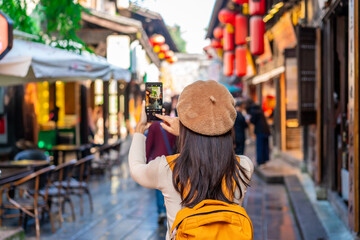 Young female tourist taking a photo of the Jinli Ancient Street in Chengdu, China