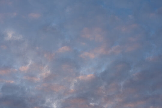 Photo texture of the sky with pink clouds during sunset.