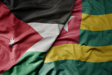 big waving national colorful flag of togo and national flag of jordan.