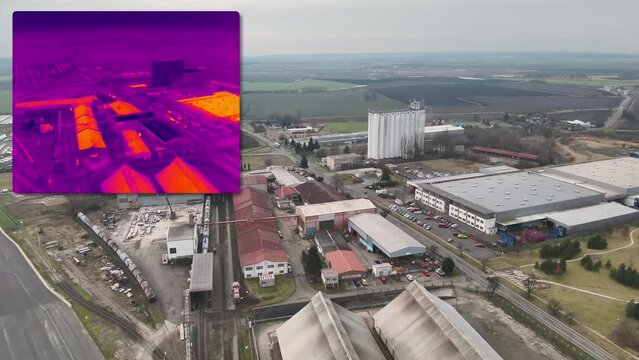 Aerial infrared thermal view of industrial zone with factories and warehouses, in purple and yellow hues
