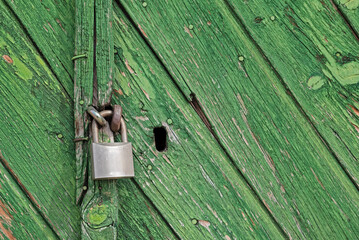 lock with padlock on old wooden green door