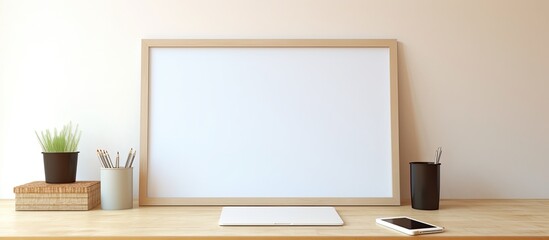 A white rectangular whiteboard is placed on a wooden desk alongside a laptop, cell phone, and other electronic devices. It serves as a computer monitor accessory for the display device on the desk