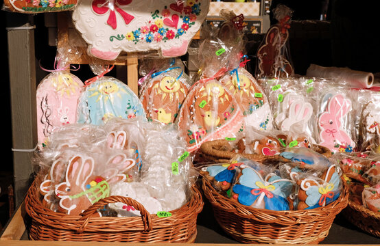 Traditional Easter gingerbread cookies in the shape of a colorful egg with drawings of a hare and chickens are sold at a market