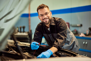Mechanic technician doing his job while smiling for the camera. - 761358772