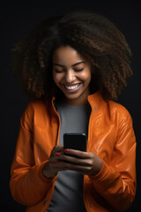 Woman with curly hair is smiling while holding cell phone