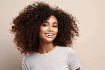 Fototapeta premium Woman with curly hair is smiling and wearing white shirt