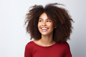 Woman with curly hair is smiling and looking up at camera