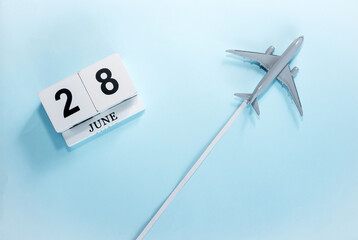 June calendar with number  28. Top view of a calendar with a flying passenger plane. Scheduler....