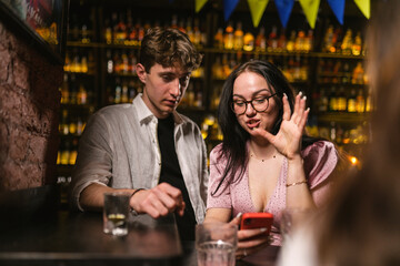 Couple in love on romantic date with alcoholic cocktails near patriotic bar counter. Romantic date...