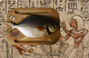 Wędzona ryba na drewnianej desce do krojenia. Egipskie hieroglify. Przezroczyste tło. 
