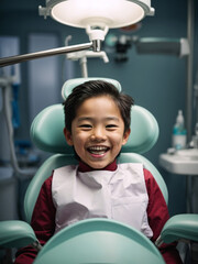 A smiling young asian boy in a dental chair. Check up by a dentist.
