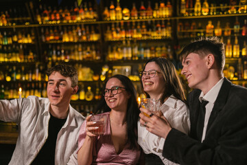 Meeting guys and young women after work in stylish restaurant. Young people at party in nightclub with various cocktails