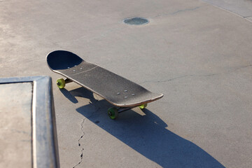 A black skateboard  with yellow wheels on the streets of California late afternoon