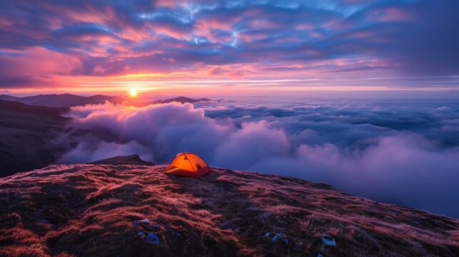 A small orange tent is set up on a grassy hillside overlooking a cloudy sky