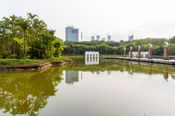 Spring scenery at Yuanmei Park in Dongguan, China. A tranquil lake is surrounded by lush trees.




