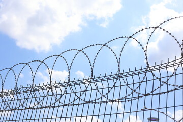 stainless steel razor wire fence. barbed wire against blue sky