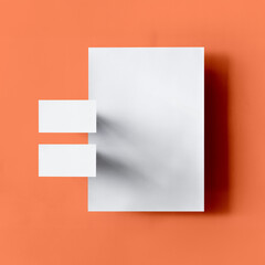 composition of blank paper business card and letterhead on orange background for branding mockup