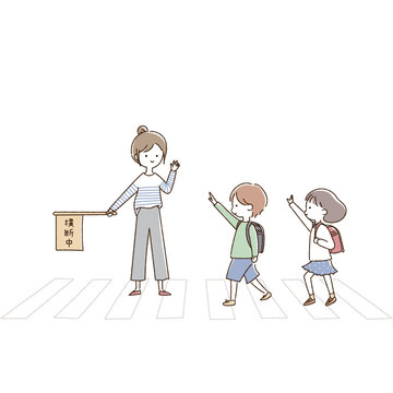横断歩道を手を挙げて渡る小学生と見守るPTAの女性
