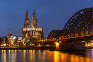 Kölner Dom bei Nacht mit der Hohenzollernbrücke, Die gotische Kathedrale  in Köln, Nordrhein-Westfalen, ist eines der bekanntesten Bauwerke Deutschlands.