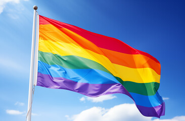 Bright rainbow pride flag waving in blue sky. Ideal for LGBTQ+ rights, pride events, and equality campaigns. High-quality image for social media, banners, and promotional materials.