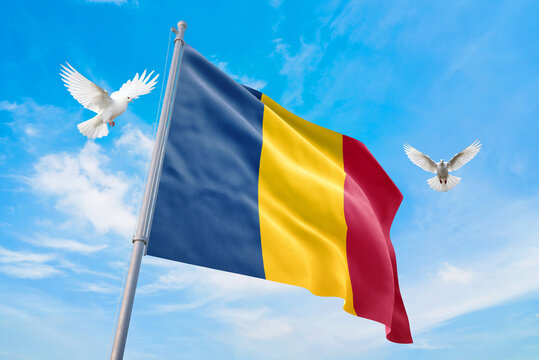Waving flag of Chad in beautiful sky and flying pigeons. Chad flag for independence day. The symbol of the state on wavy fabric.