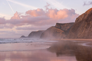 Sunset at Cordoama Beach in Portugal. Atlantic Ocean and rocky cliffs at sandy beach