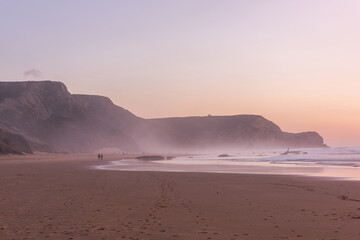 Sunset at Cordoama Beach in Portugal. Atlantic Ocean and rocky cliffs at sandy beach