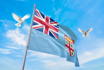 Waving flag of Fiji in beautiful sky and flying pigeons. Fiji flag for independence day. The symbol of the state on wavy fabric.
