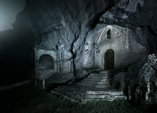 Cover of the hermitage carved into the rock of San Bernabe in Ojo Guare&ntilde;a, illuminated on a cold foggy night
