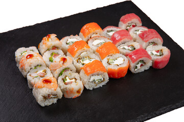 Sushi set served on black stone tray. Various types of sushi rolls served on a slate slab. Isolated on white.