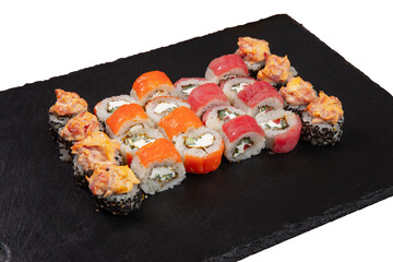 Sushi set served on black stone tray. Various types of sushi rolls served on a slate slab. Isolated on white.