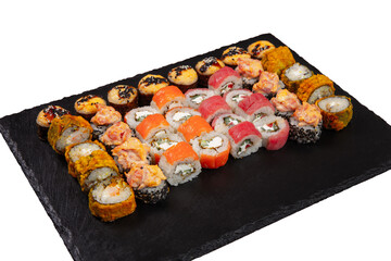 Sushi set served on black stone tray. Various types of sushi rolls served on a slate slab. Isolated on white.