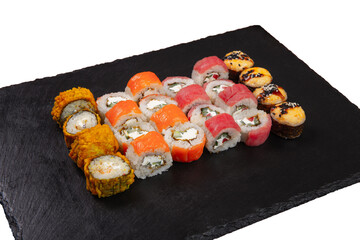 Sushi set served on black stone tray. Various types of sushi rolls served on a slate slab. Isolated on white.