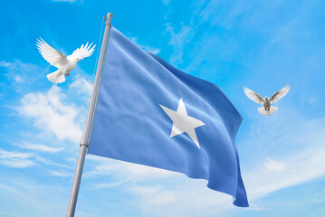 Waving flag of Somalia in beautiful sky and flying pigeons. Somalia flag for independence day. The symbol of the state on wavy fabric.