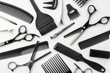 Black hairdressing tools and various hairbrushes on white background - obrazy, fototapety, plakaty