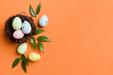 Fototapeta premium Colorful easter eggs in nest on table background with copy space top view