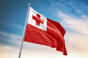 Waving flag of Tonga in blue sky. Tonga flag for independence day. The symbol of the state on wavy fabric.