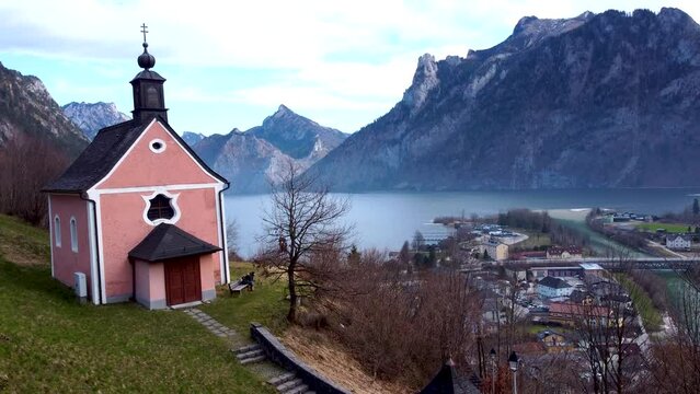 Cute little pink chapel on Kalvarienberg with Traunsee lake in the background, peaceful and serene