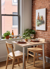 Two wooden chairs at a wooden table in front of a brick wall with a painting of wine bottles hanging on it.