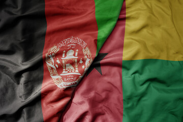 big waving national colorful flag of guinea bissau and national flag of afghanistan.